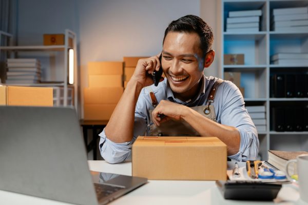 A business owner sells products on websites and online platforms. He is on the phone with a customer